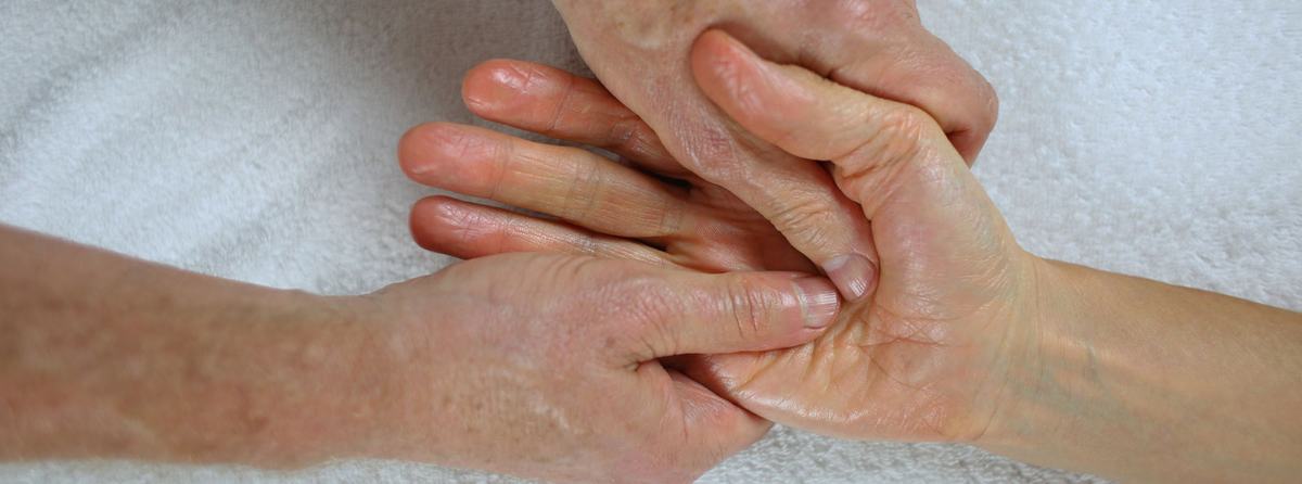 Handmassage waarbij de duimen de handpalm bewerken